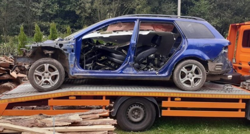 częściowo rozmontowany skradziony samochód stojący na lawecie