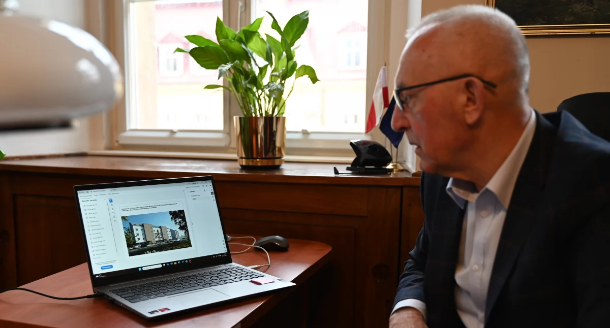 Burmistrz Lubawki Andrzej Wojdyła ogląda wizualizacje nowych budynków w Lubawce